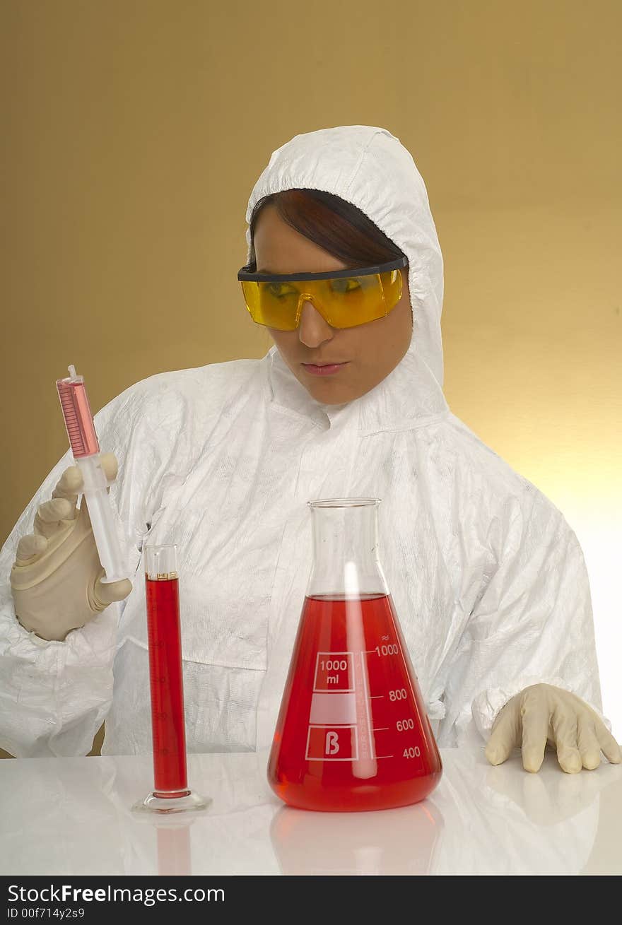 Beautiful female young scientist wearing glasses while doing a blood test. Beautiful female young scientist wearing glasses while doing a blood test