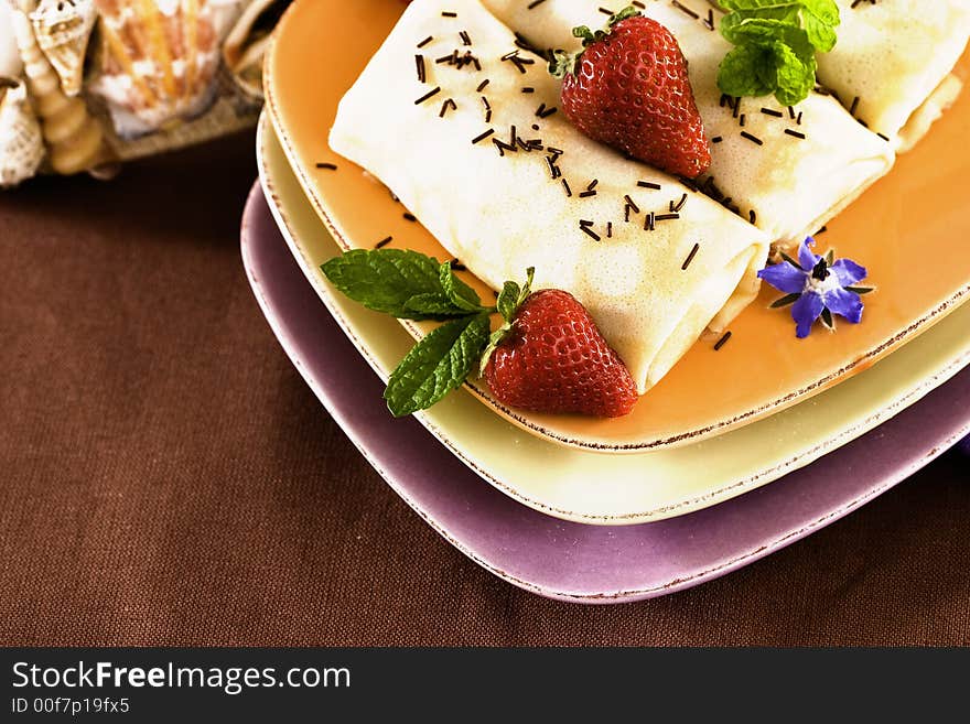 Crepes On Golden Plate With Mint, Chocolate Sprinkles, Strawberries And Edible Borage Flowers. Crepes On Golden Plate With Mint, Chocolate Sprinkles, Strawberries And Edible Borage Flowers