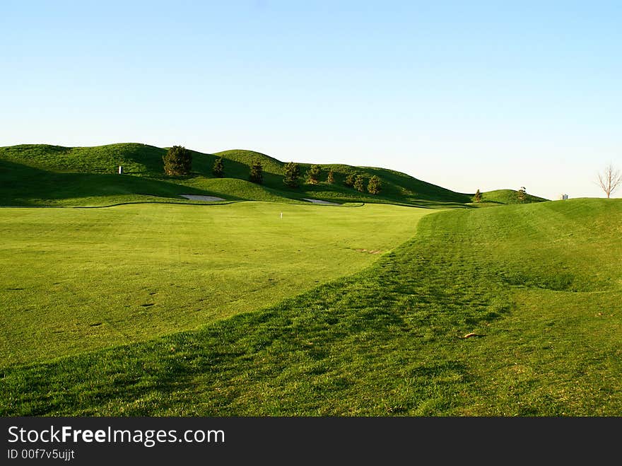 Photo of green golf course with beutiful clouds background. Photo of green golf course with beutiful clouds background