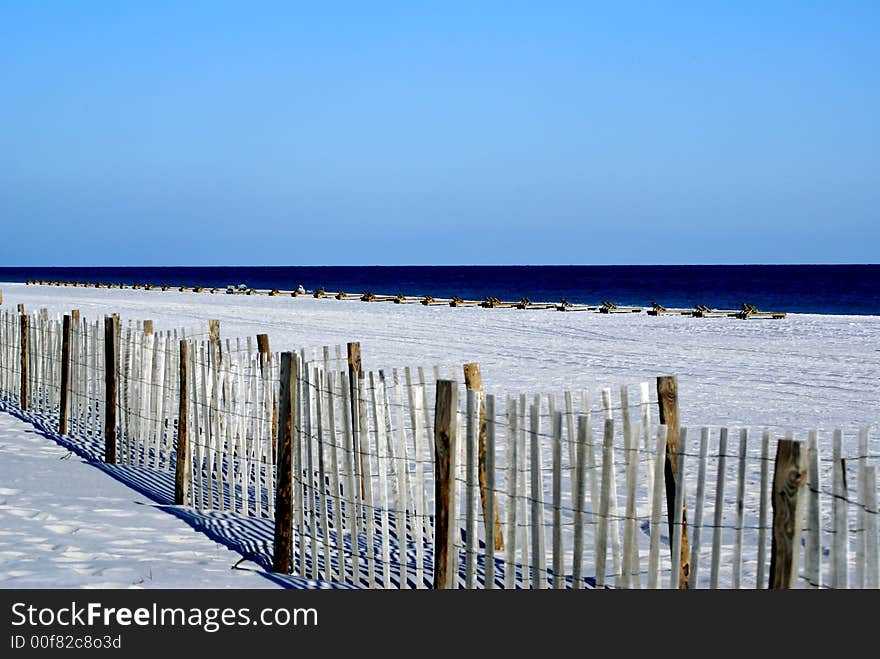 Fences,chairs on white sand along the Gulf of Mexico. Fences,chairs on white sand along the Gulf of Mexico