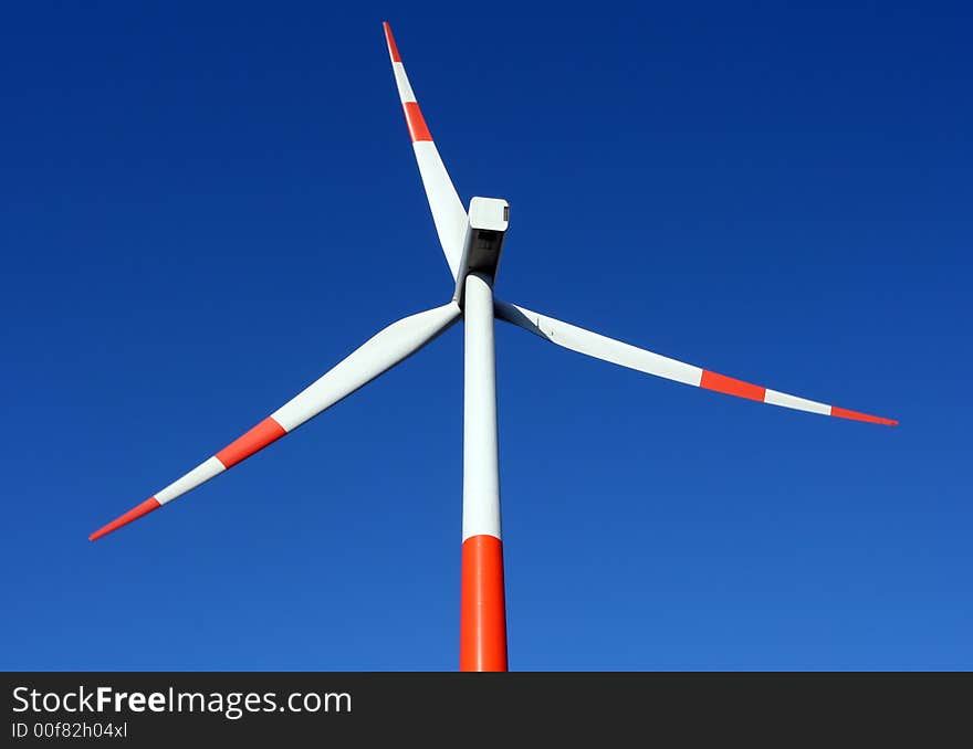 A red/ white windmill against a clear blue sky. A red/ white windmill against a clear blue sky