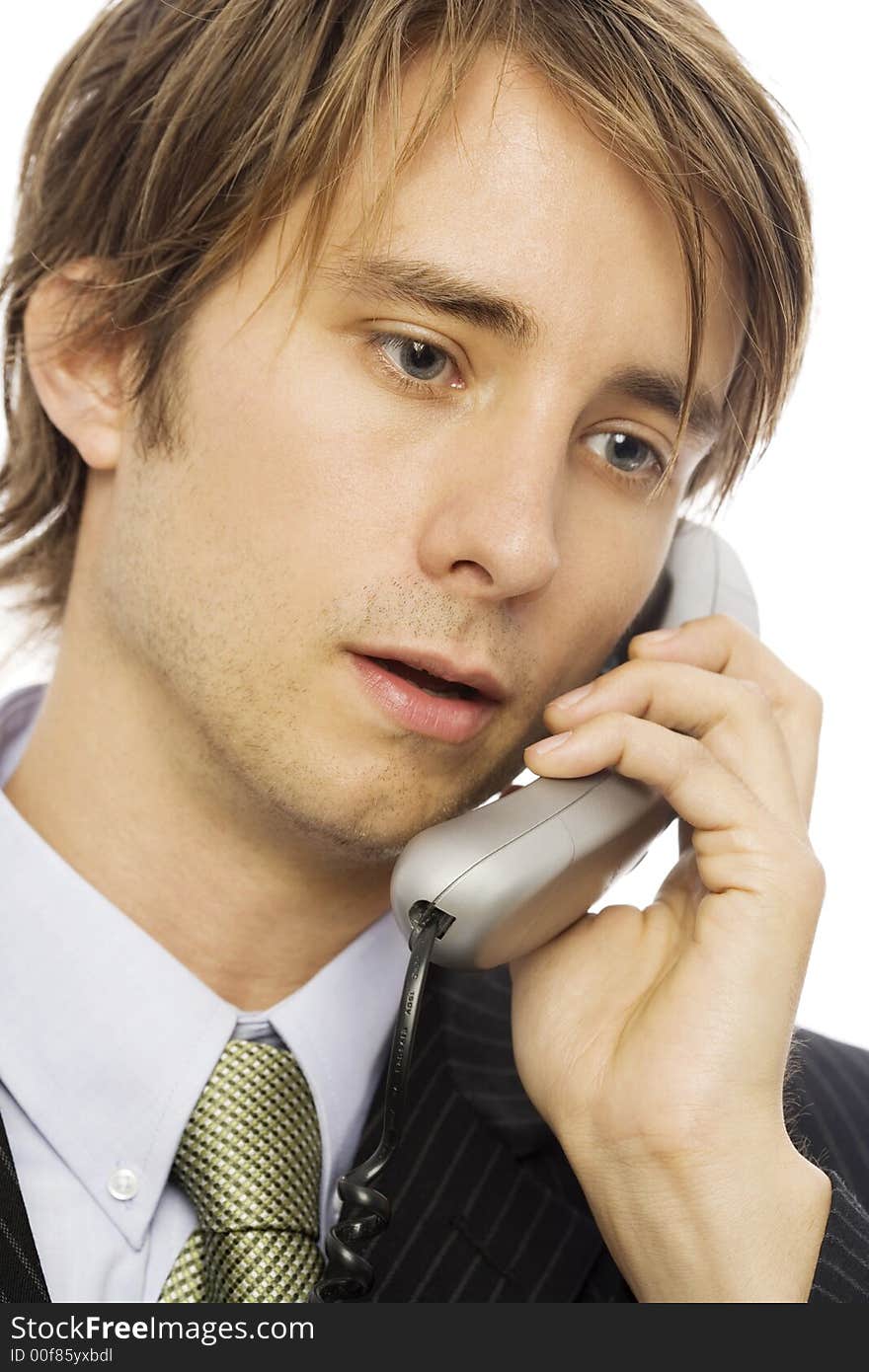 Businessman in a suit uses a corded telephone. Businessman in a suit uses a corded telephone