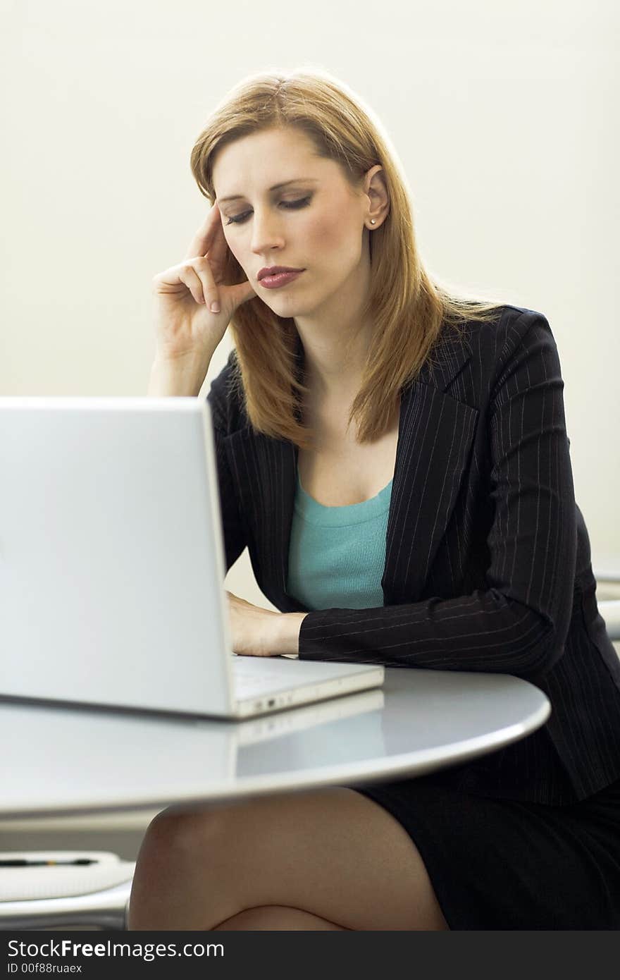 Businesswoman works with her laptop at a desk. Businesswoman works with her laptop at a desk