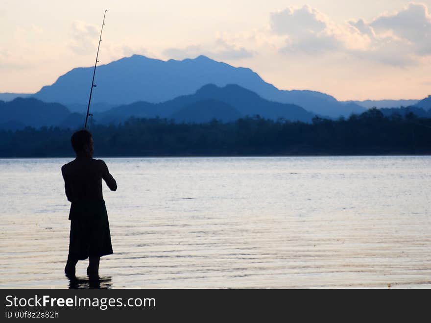 A fishman at work in the lake of khao leam dam, kanchanaburi, thailand. A fishman at work in the lake of khao leam dam, kanchanaburi, thailand