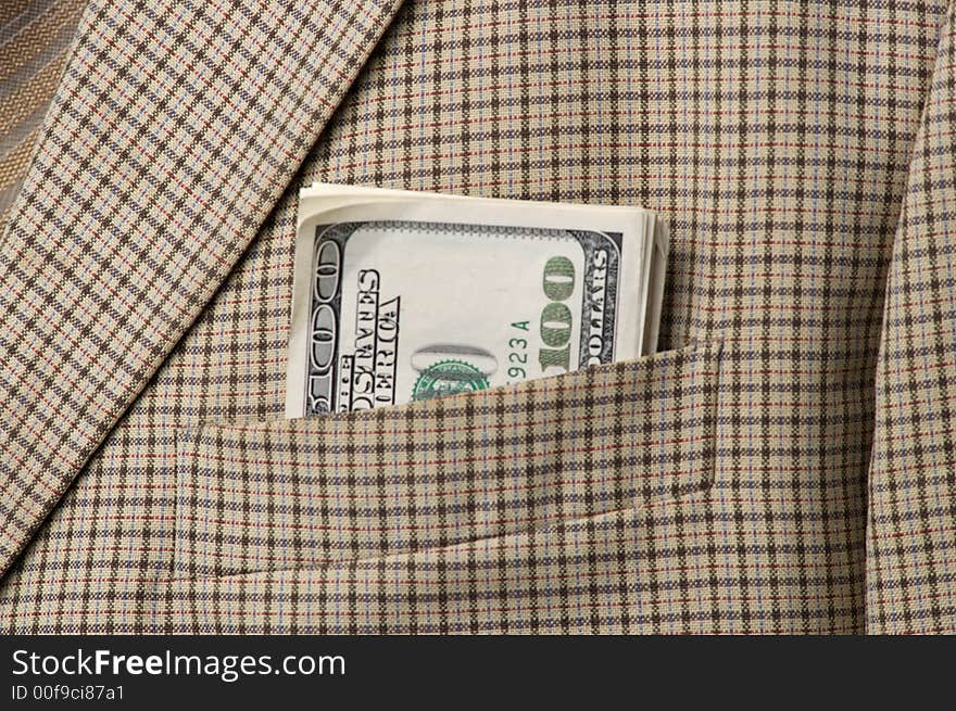 Money in a pocket of a checkered jacket