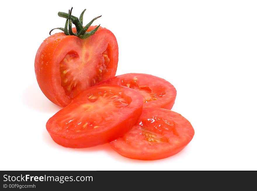 Vine ripe red tomato with slices on a white background. Vine ripe red tomato with slices on a white background