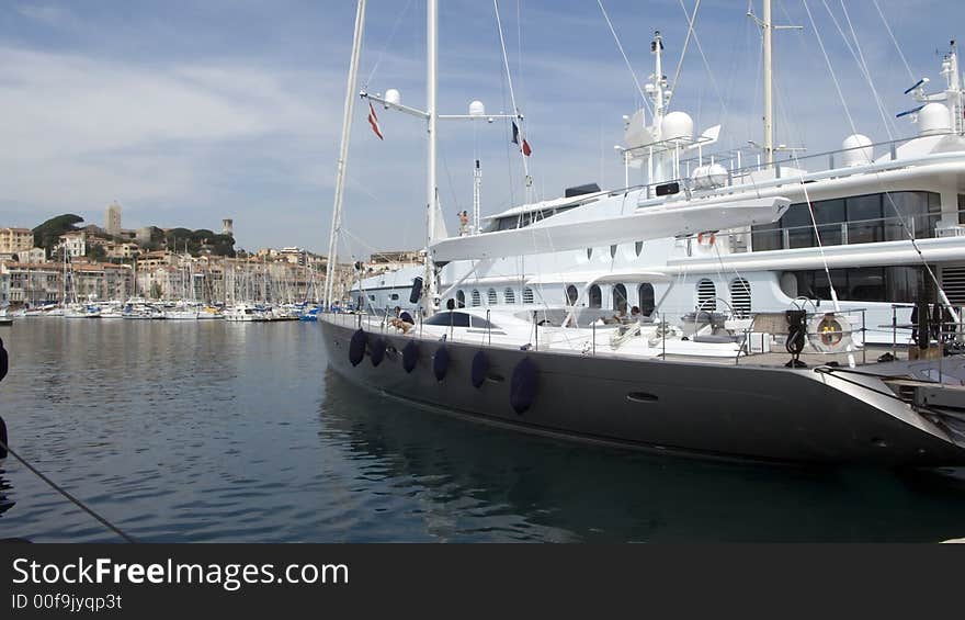 View of the old port of Cannes with modern yachts in foreground. View of the old port of Cannes with modern yachts in foreground