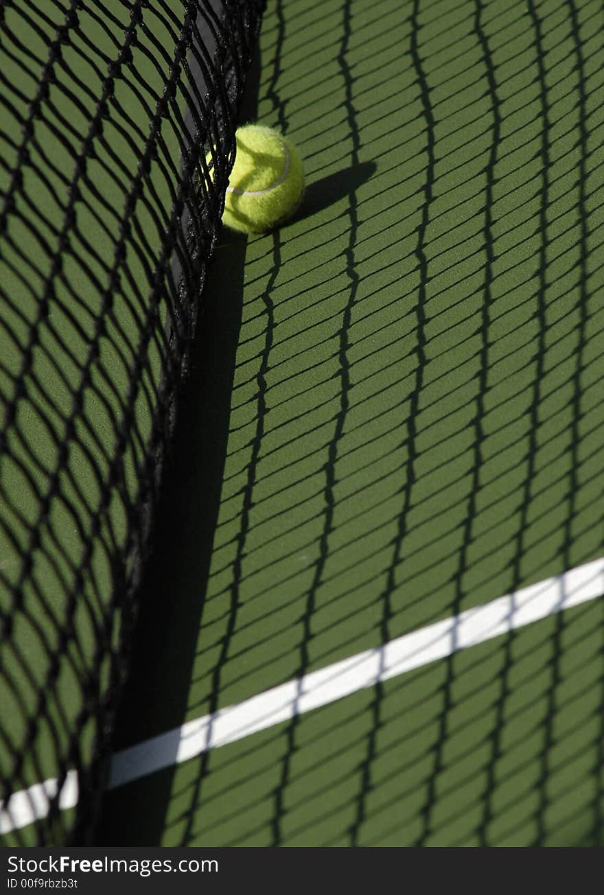 Tennis Ball on Court in Shadow