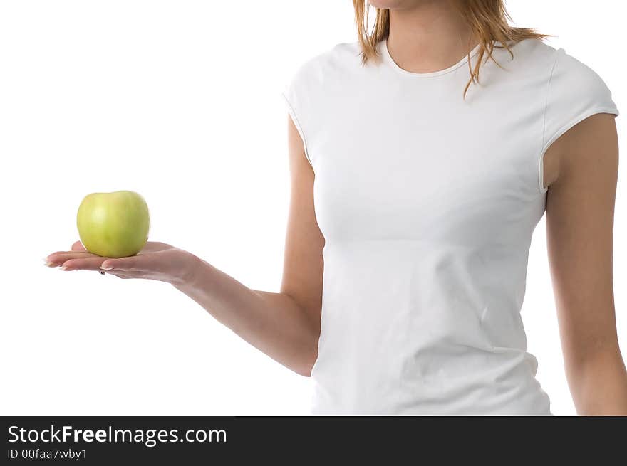 The girl holds a green apple on a palm