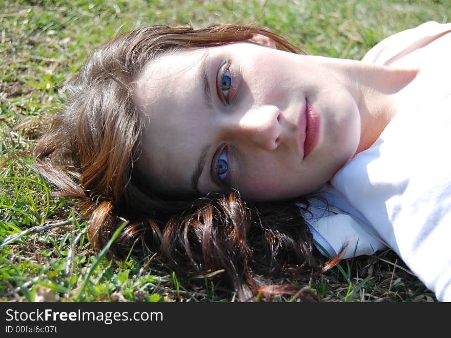 Beautiful young female face on grass