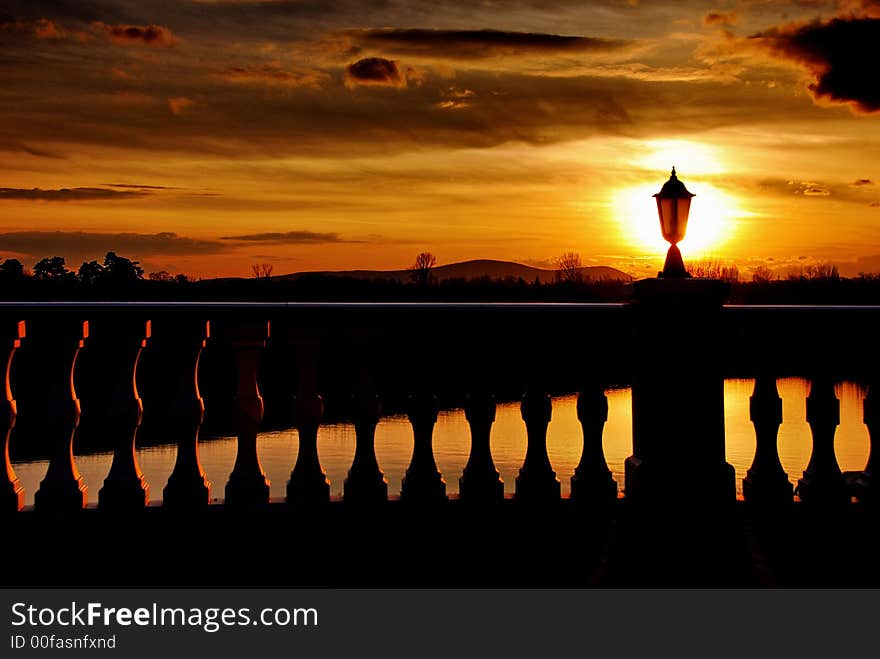 The sun shines behind a lamp on a fence creating a weird light effect. The sun shines behind a lamp on a fence creating a weird light effect