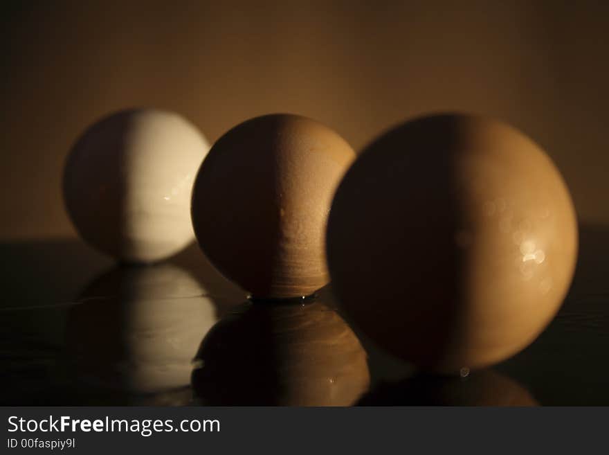 Three eggs with shadow on a dark background