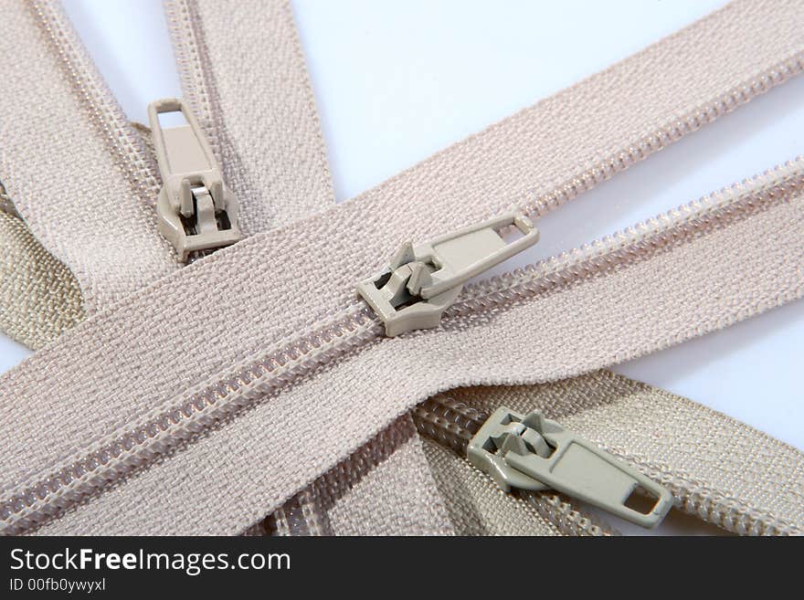 Three beige opened zippers for clothes