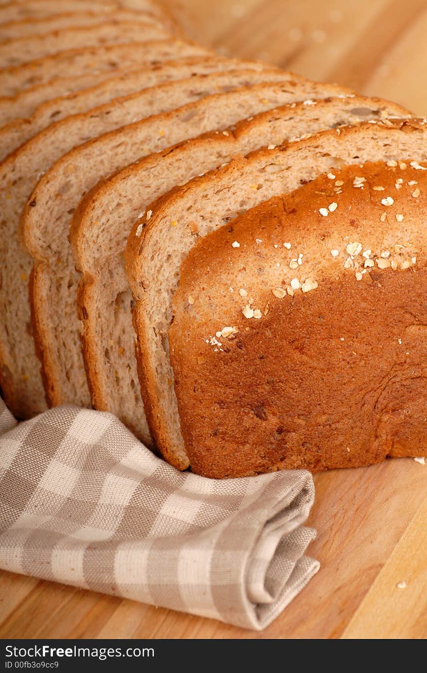 A close up of a loaf of multi grain bread on a cutting board