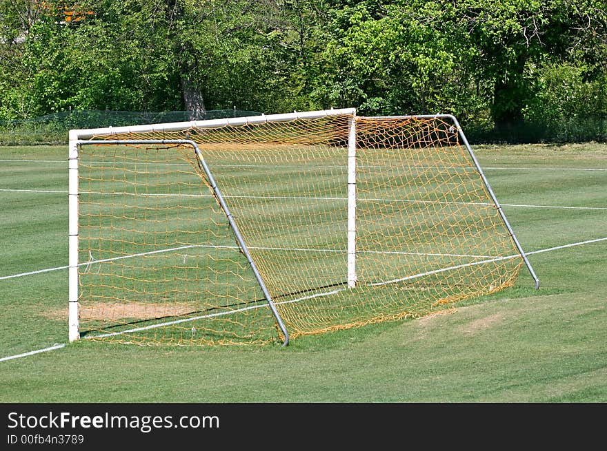 The net goal on a green soccer field. The net goal on a green soccer field