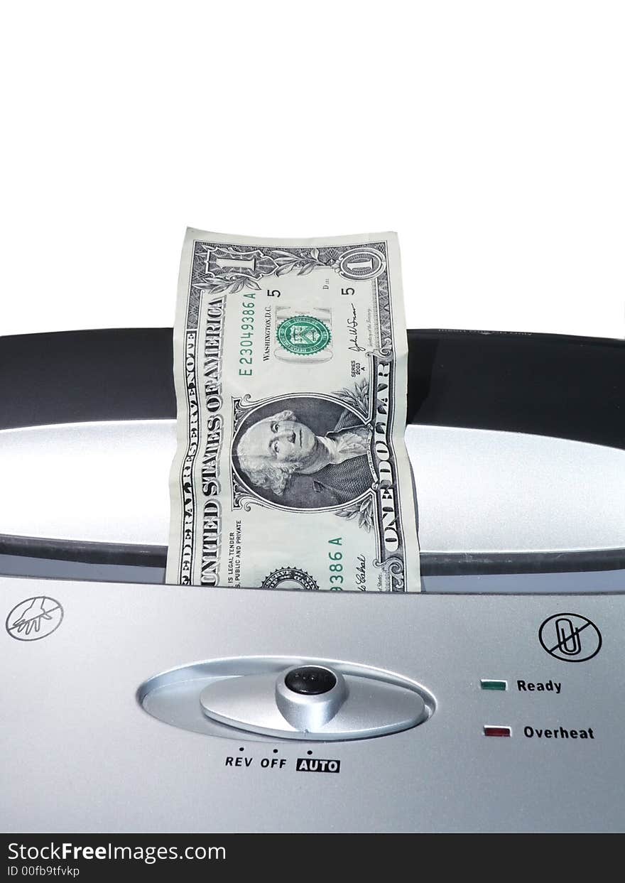 Concept photo of a dollar bill being shredded by a paper shredder depicting the weakened dollar value. Concept photo of a dollar bill being shredded by a paper shredder depicting the weakened dollar value