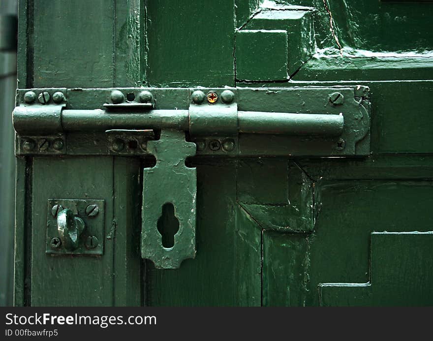 Closeup of green bolt and door