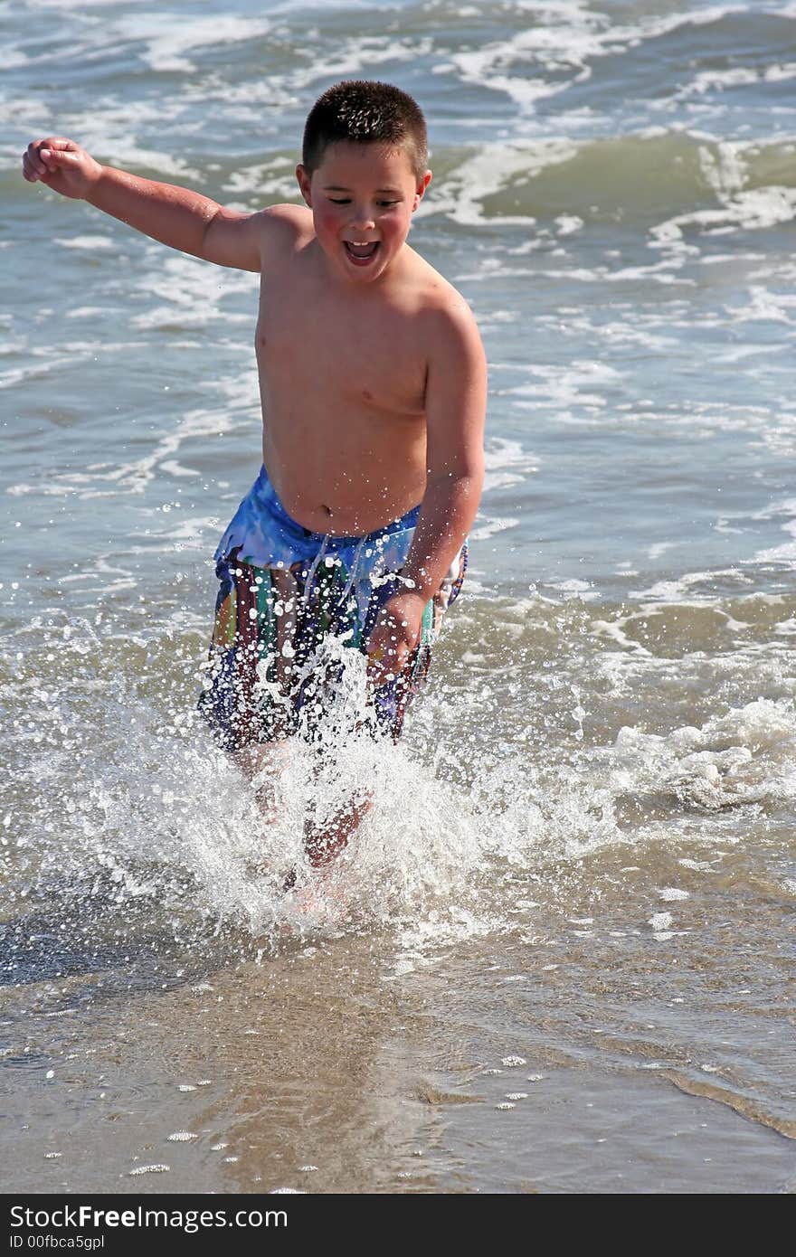 Little boy splashing in the surf