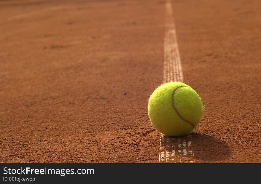 The tennis ball lie on the line. The tennis ball lie on the line