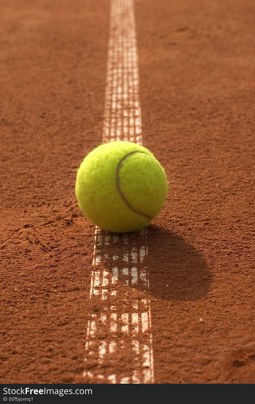 The tennis ball lie on the line. The tennis ball lie on the line