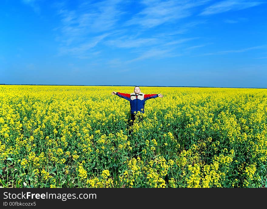 Happy boy on meadow on blue sky background