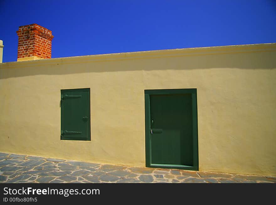 Yellow building with chimney against blue background