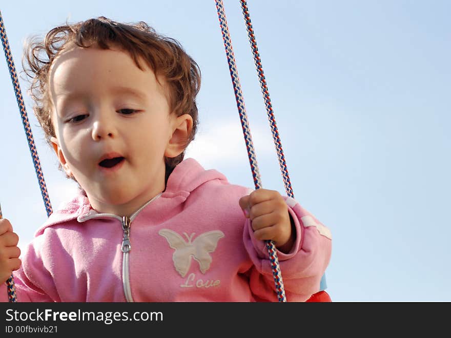 A little child swinging outdoors