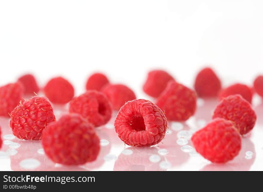 Raspberries on a white surface with water drops. Raspberries on a white surface with water drops.