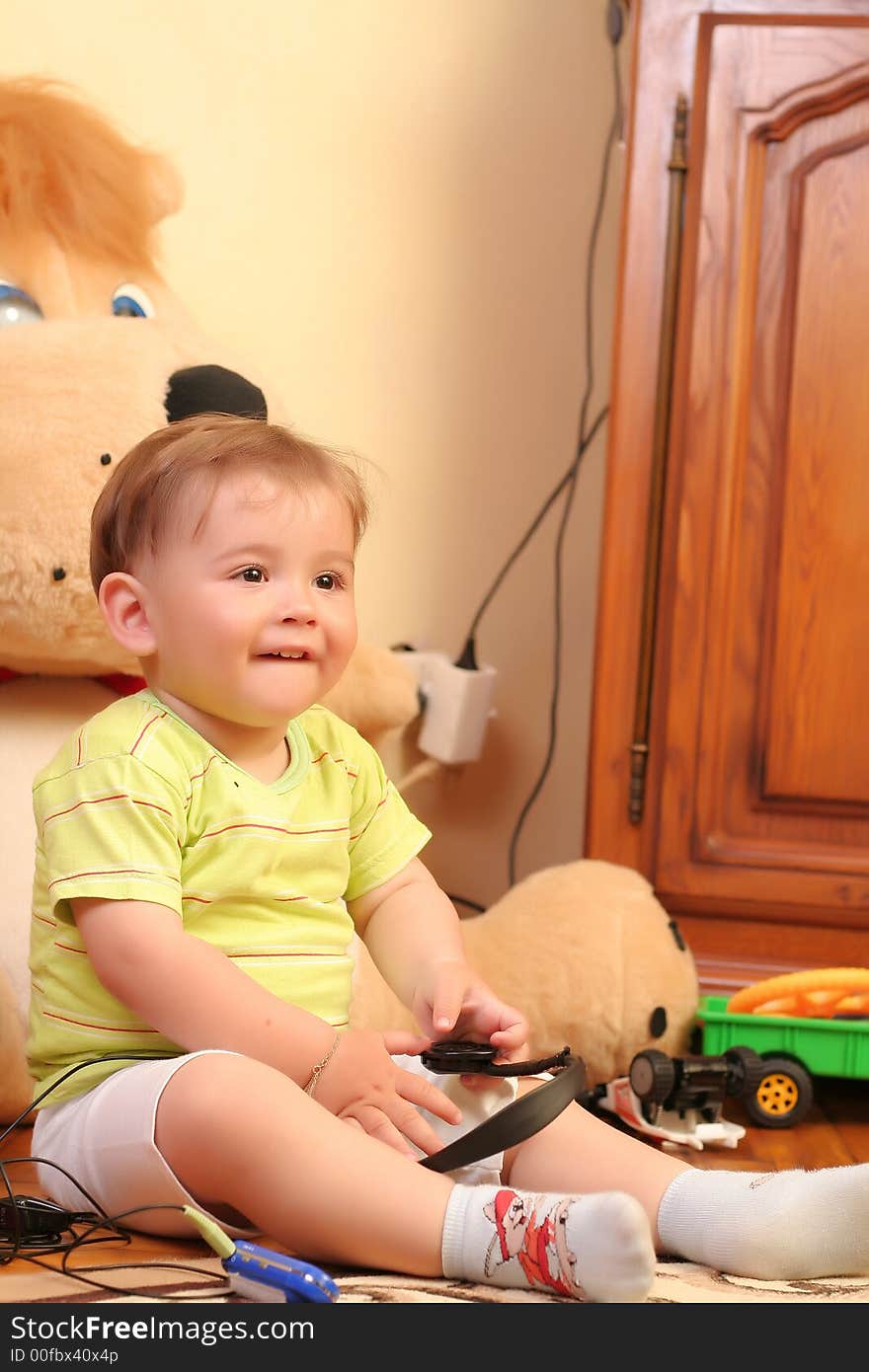 Little blond baby boy playing with toys at home