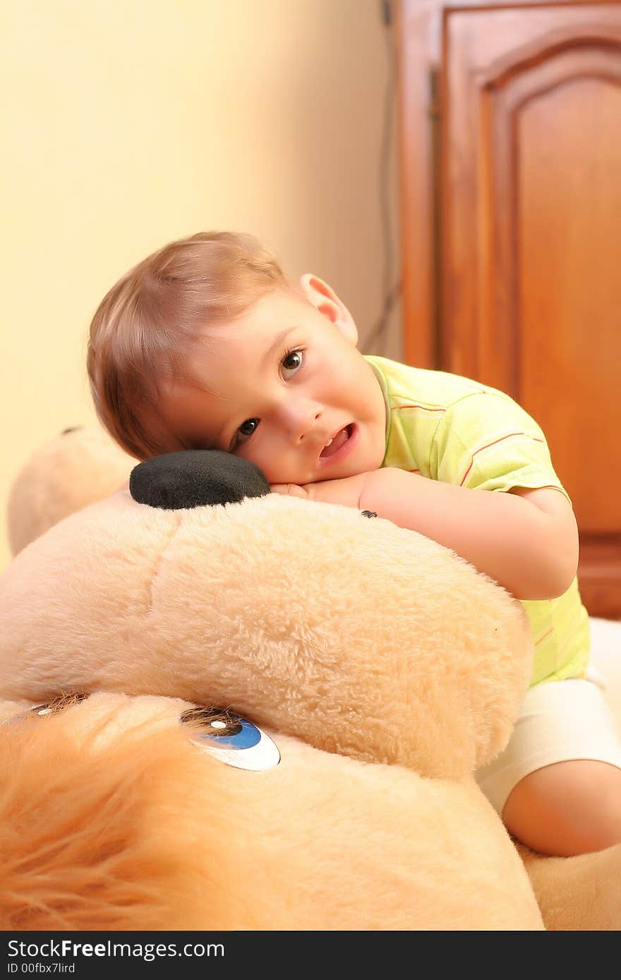 Little blond baby boy playing with toys at home