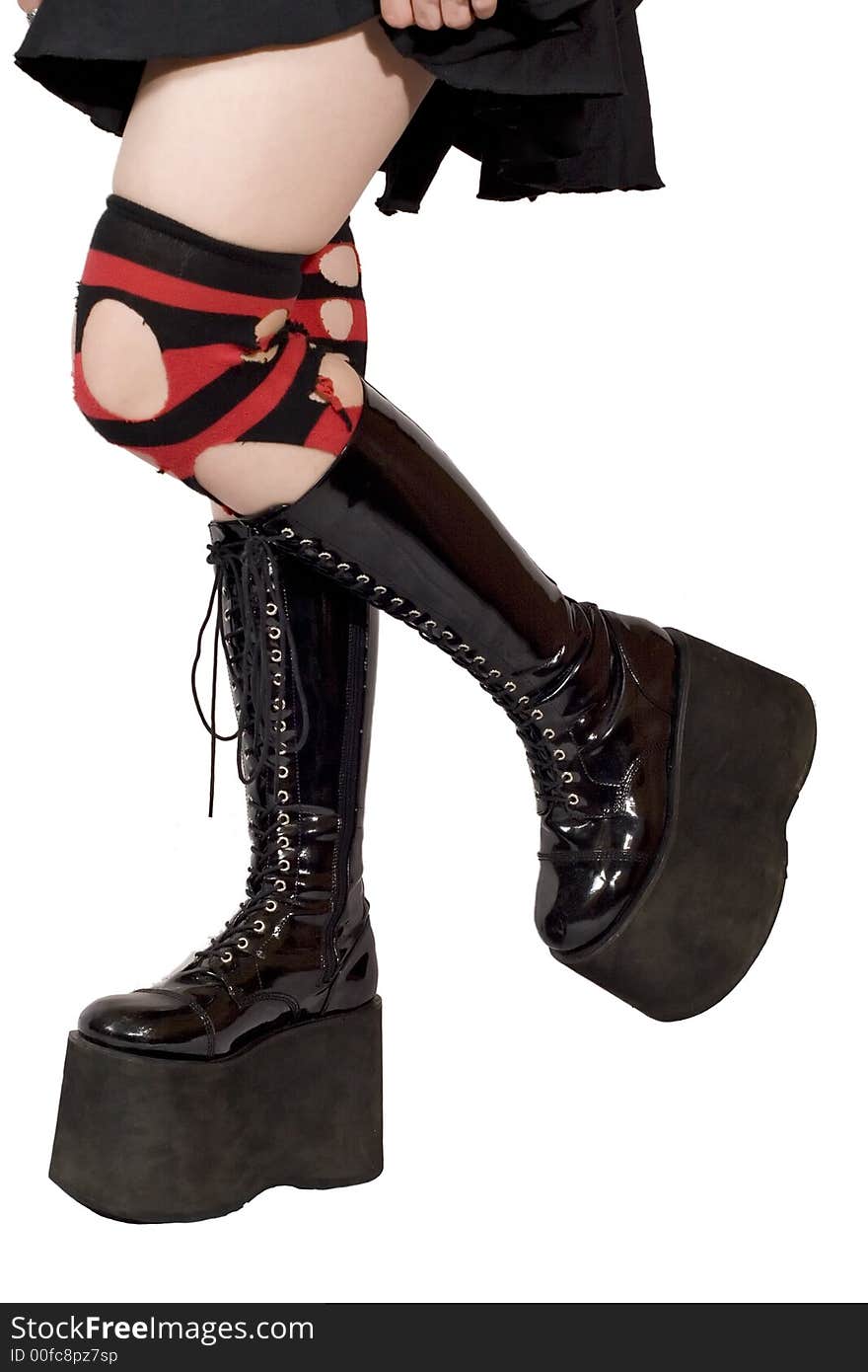 Black leather boots with big soles, being worn by a woman with ripped stripey socks