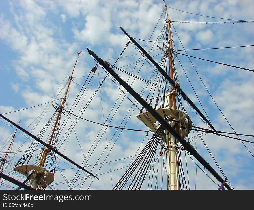 Masts of a ship pointing up through blue skies. Masts of a ship pointing up through blue skies.