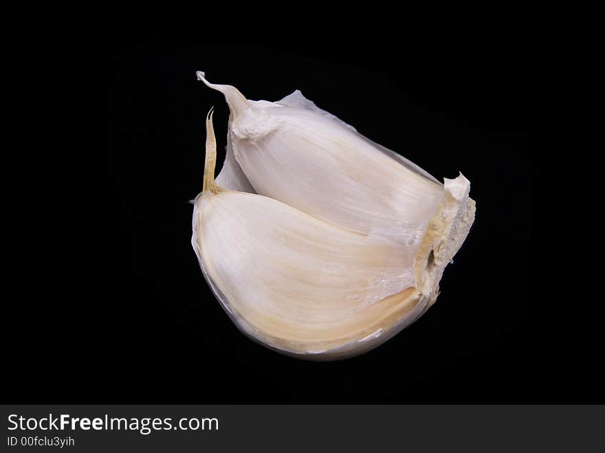 2 Clove of Garlic peeled open over black background