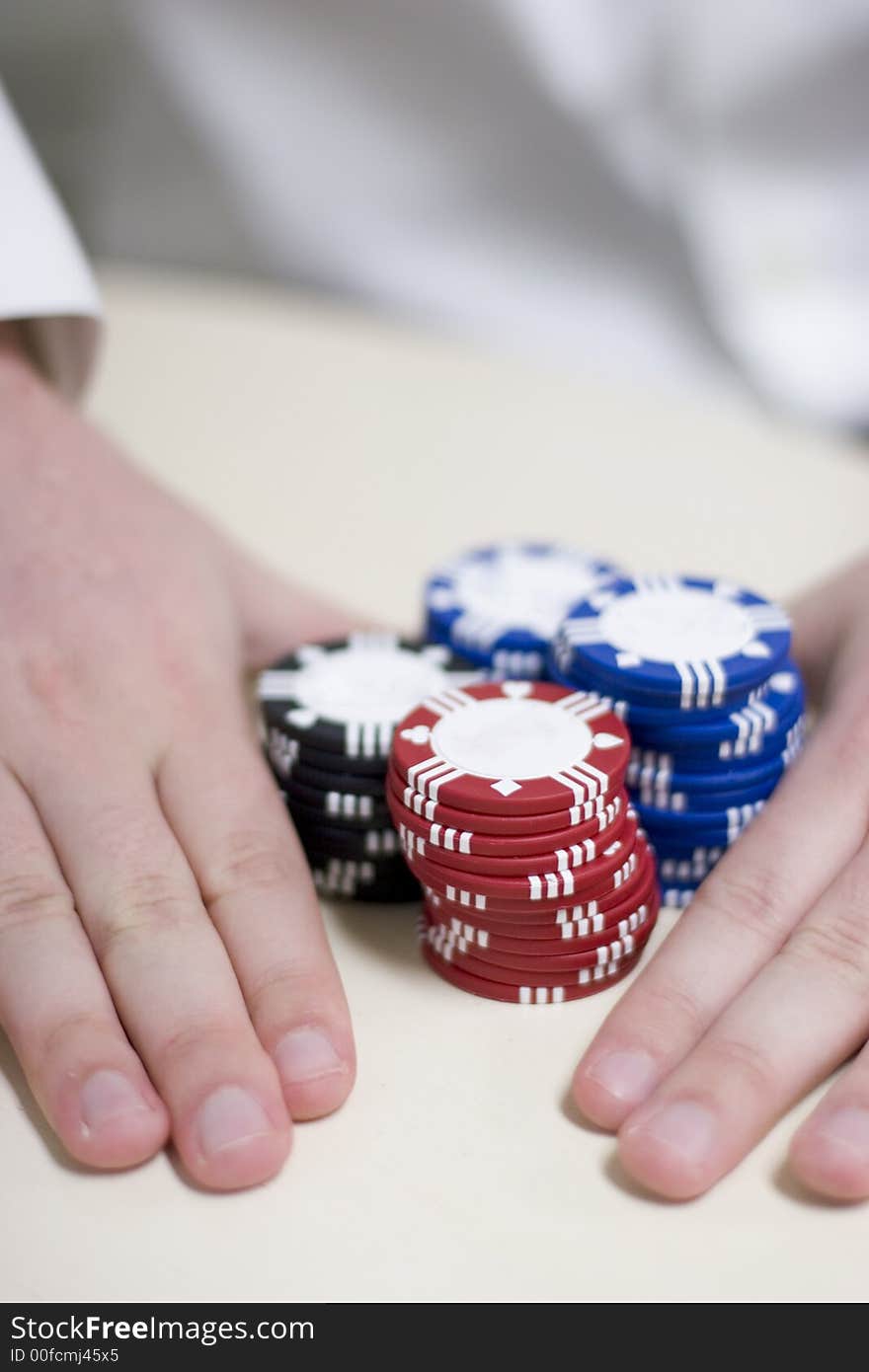 Man holding all the chips in his hand pushing the chips across the table. Man holding all the chips in his hand pushing the chips across the table