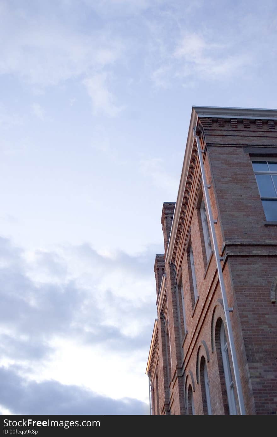 Old red brick building with big cloudy blue sky