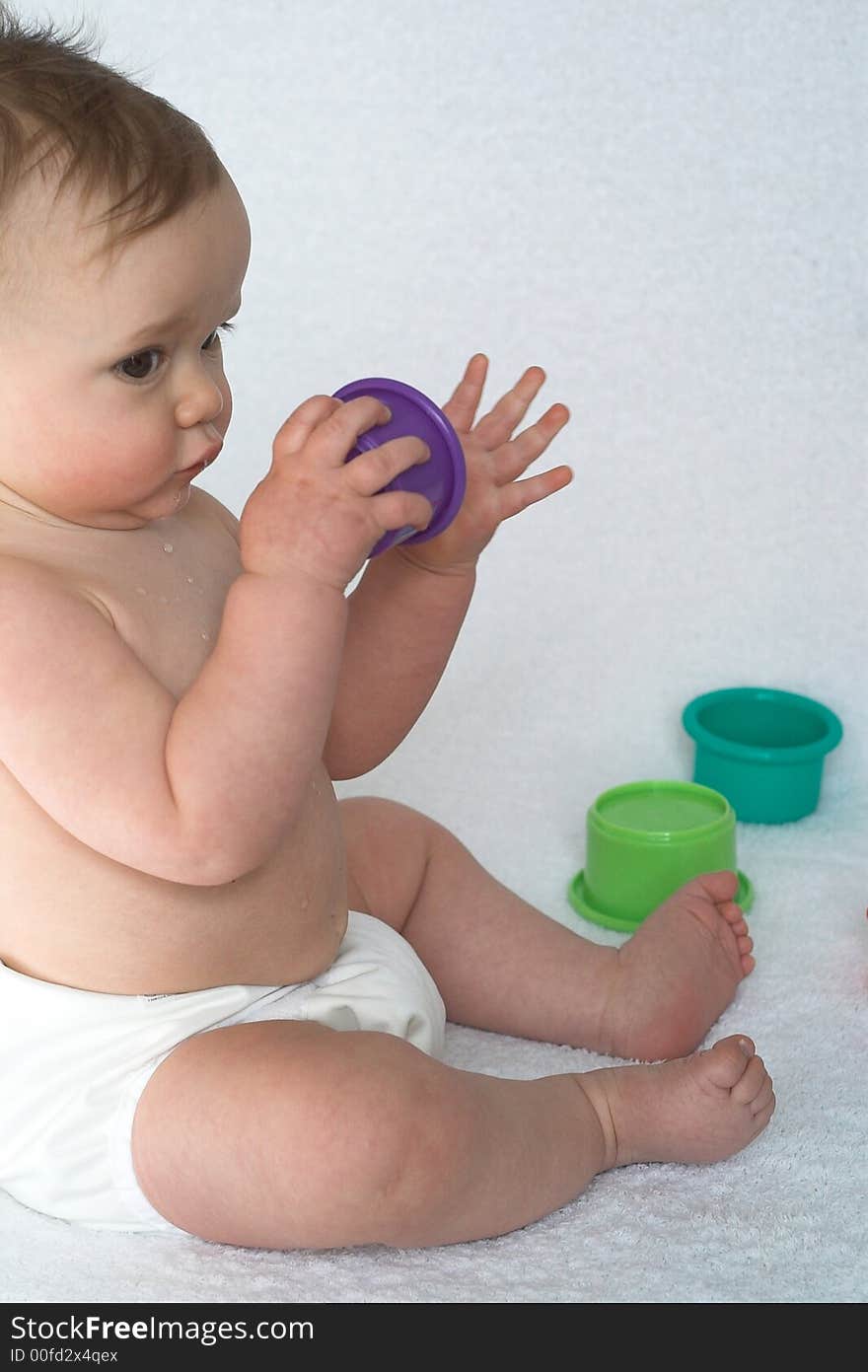 Image of adorable baby playing with stacking cups. Image of adorable baby playing with stacking cups