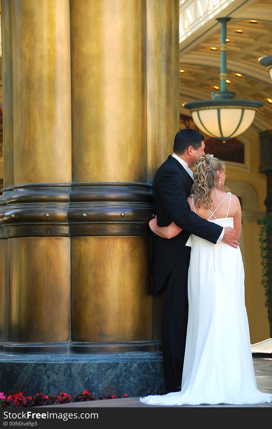 Newly married couple posing next to a pillar. Newly married couple posing next to a pillar