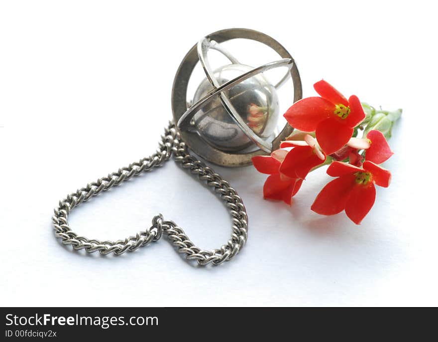 Little heart made of a chain, metal globe and red flowers. Little heart made of a chain, metal globe and red flowers