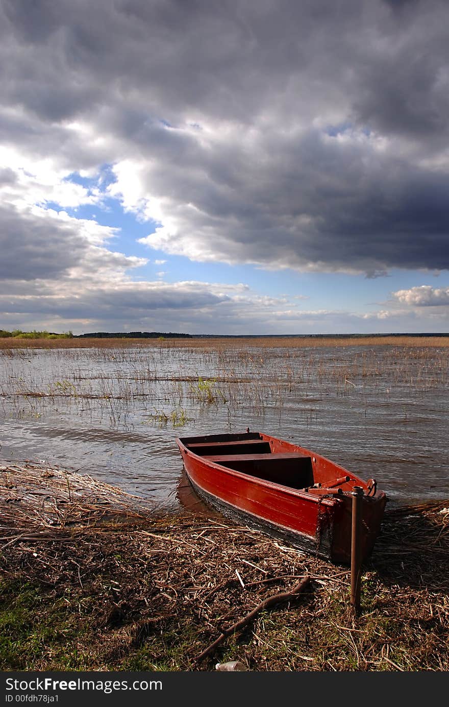 A boat by the lake on a stormy day. A boat by the lake on a stormy day