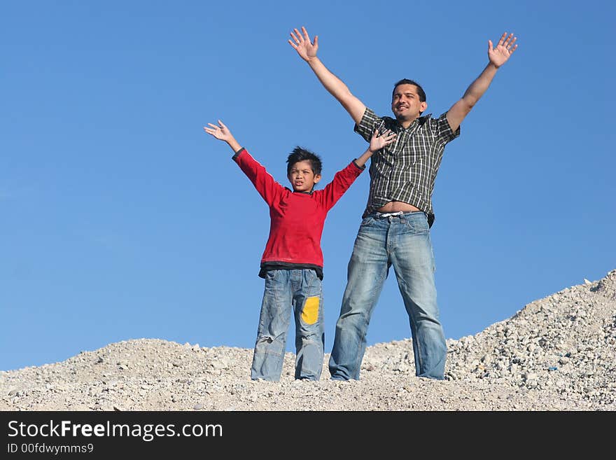 Father and his son standing on the hill and enjoying the day