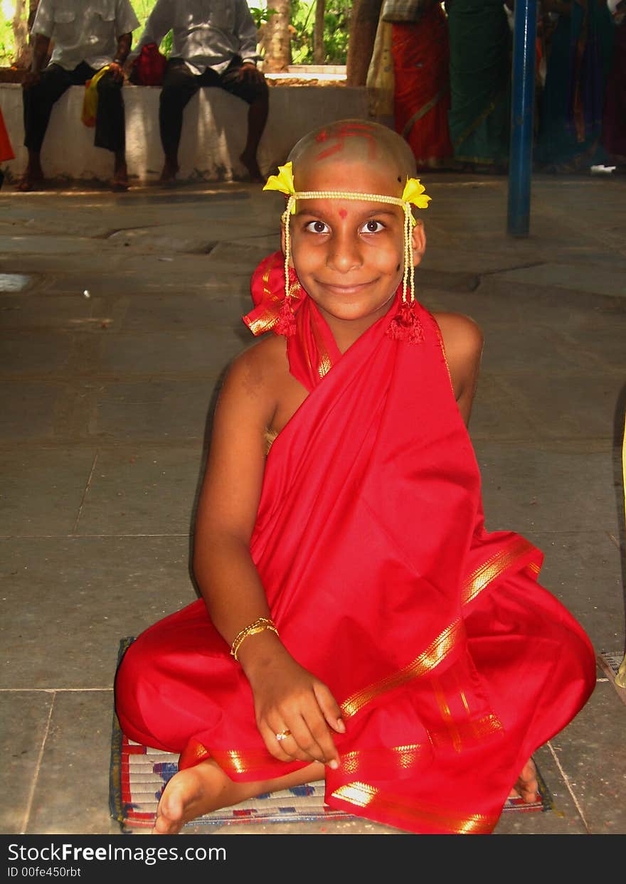 A boy in the dress of an Indian Monk sitting for a thread ceremony. A boy in the dress of an Indian Monk sitting for a thread ceremony.