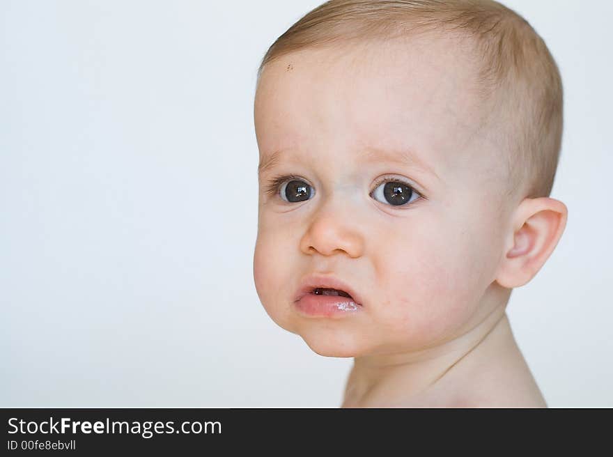 Image of beautiful 11 month old baby boy  sitting in front of a white background. Image of beautiful 11 month old baby boy  sitting in front of a white background