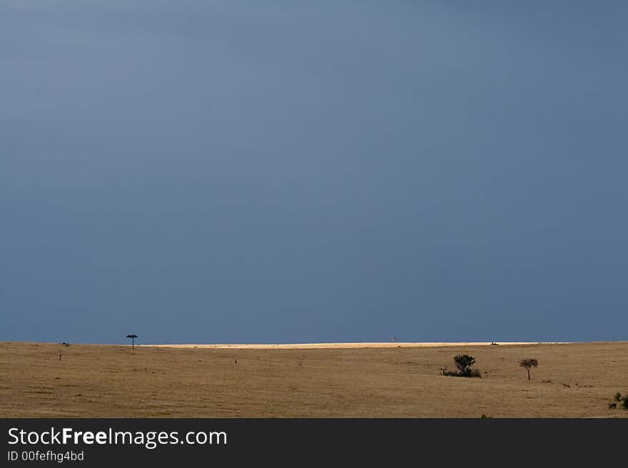 Rainclouds and sunshine over serengeti plains, masai mara, kenya