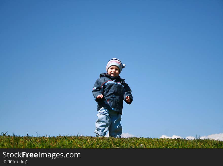 The child on a glade on a background of the sky. The child on a glade on a background of the sky