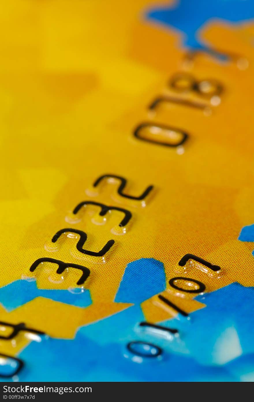 Close-up of digits on a credit card. Very shallow depth of field. Focus on numbers 3, 2 and 7. Visible texture of the card.