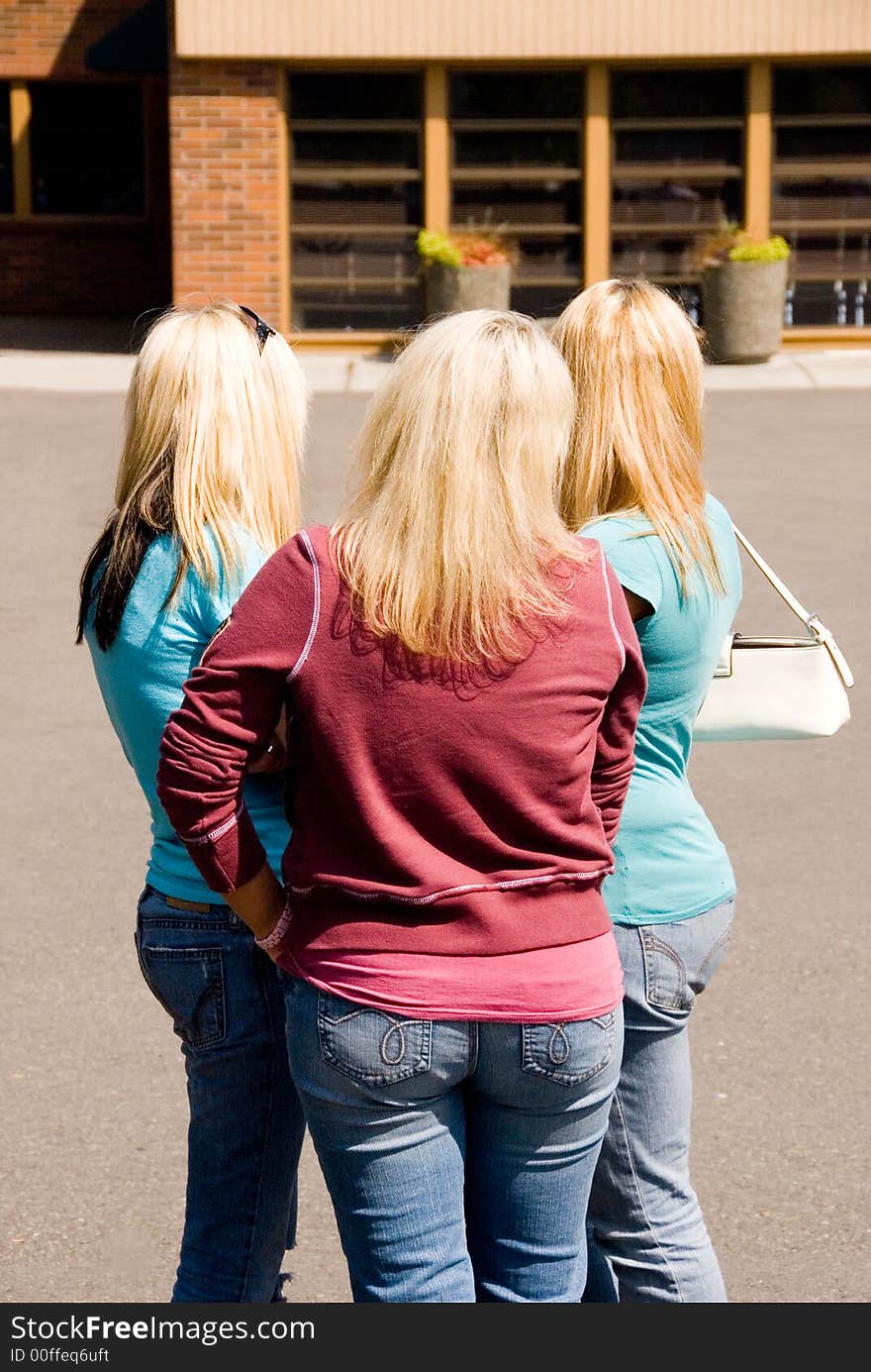 Three blond girls in a group talking. Three blond girls in a group talking