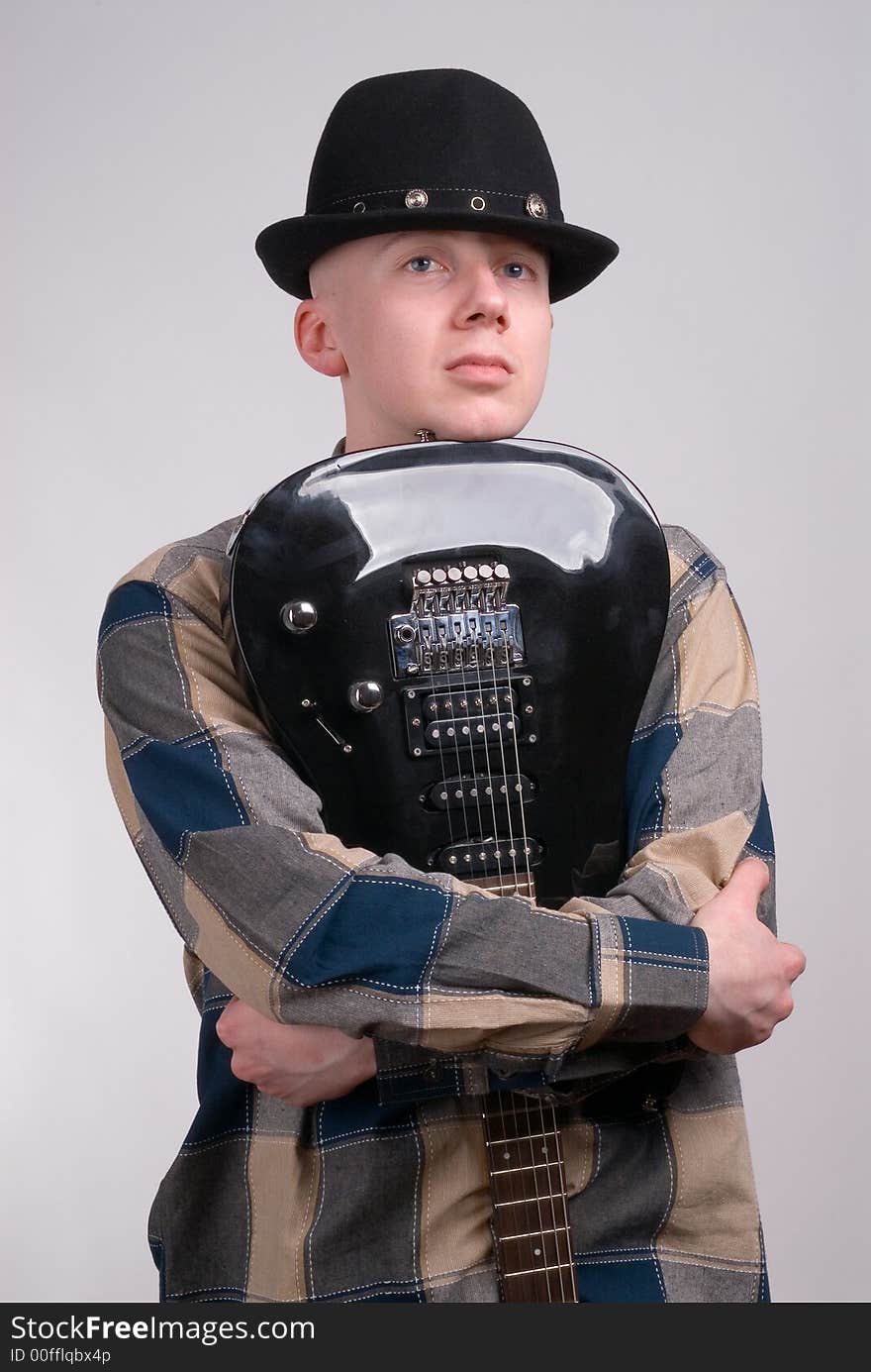 The musician with a guitar on a grey background