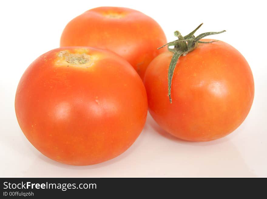 Some healthy red tomatoes on a white back drop setting. Some healthy red tomatoes on a white back drop setting.