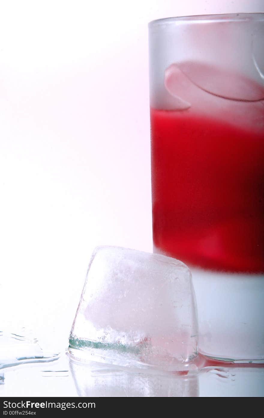 Glass with ice cube  on a mirror table. Glass with ice cube  on a mirror table