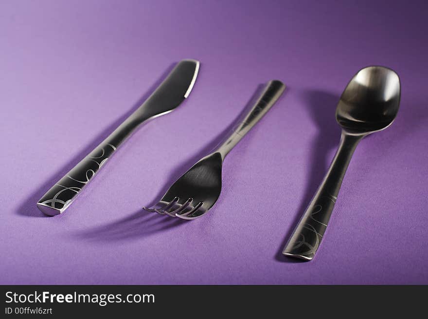 Modern spoon, fork and knife on purple table. Modern spoon, fork and knife on purple table.